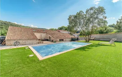 a yard with a swimming pool in front of a house at Stunning Home In Pardailhan in Pardailhan