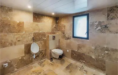 a bathroom with a toilet and a window at Stunning Home In Pardailhan in Pardailhan