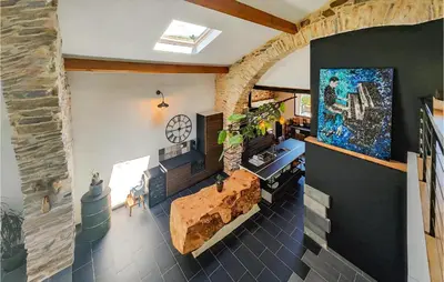 a living room with a stone wall and a fireplace at Stunning Home In Pardailhan in Pardailhan