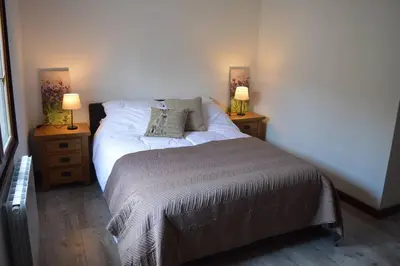 a bedroom with a bed and two night stands with two lamps at Spacious stone village house in Puivert in Puivert