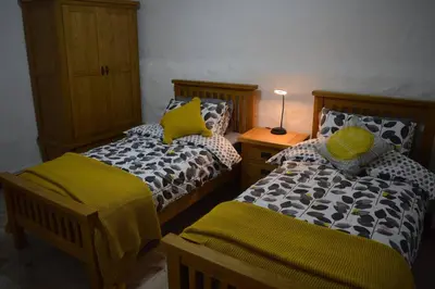 a bedroom with two beds with yellow pillows at Spacious stone village house in Puivert in Puivert