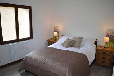 a bedroom with a bed with two night stands and a window at Spacious stone village house in Puivert in Puivert