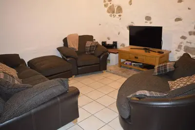 a living room with couches and a flat screen tv at Spacious stone village house in Puivert in Puivert