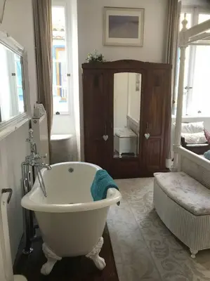 a bathroom with a white bath tub and a mirror at Riverside 4 bed house full of character and charm in Quillan