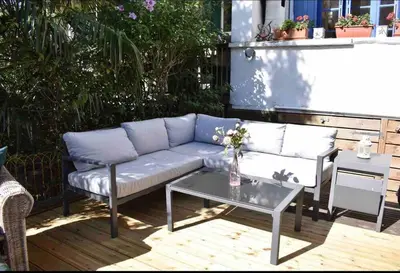a couch and a table on a patio at Riverside 4 bed house full of character and charm in Quillan