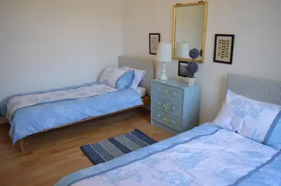 a bedroom with two beds and a dresser and a mirror at Riverside 4 bed house full of character and charm in Quillan