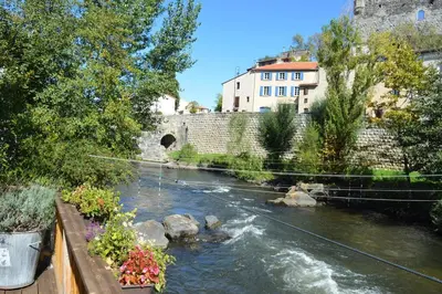 a river in a city with a bridge and buildings at Riverside 4 bed house full of character and charm in Quillan
