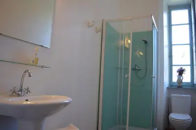 a bathroom with a glass shower and a sink at Riverside 4 bed house full of character and charm in Quillan