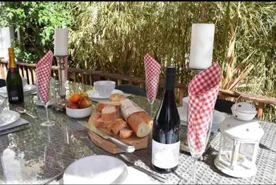 a table with a plate of bread and wine bottles at Riverside 4 bed house full of character and charm in Quillan
