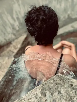 a woman in a pool of water at Notre-Dame d'Escouloubre Sources d'eaux chaudes privées et sauna in Escouloubre