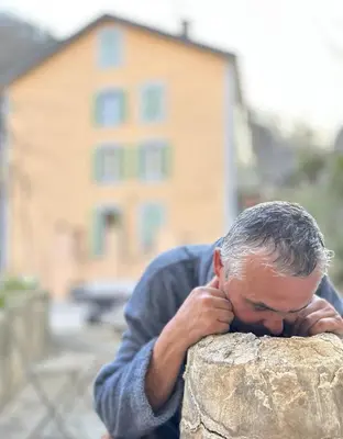 a man leaning on a rock with his head on his face at Notre-Dame d'Escouloubre Sources d'eaux chaudes privées et sauna in Escouloubre