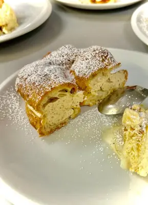 a piece of cake on a plate with powdered sugar at Notre-Dame d'Escouloubre Sources d'eaux chaudes privées et sauna in Escouloubre