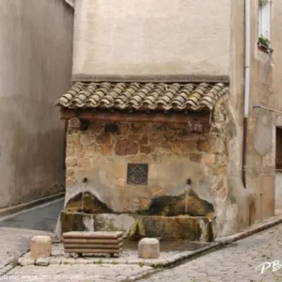 a building with a stone fireplace on a street at Le Cosy Grenier de Pauline et Flo in Cessenon