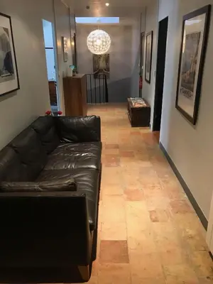 a living room with a black leather couch at Le Voyageur - Chambres d'Hôtes in Olonzac