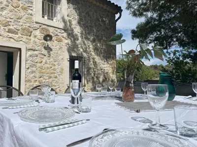 a table with glasses and a bottle of wine at Gîte de 12 personnes au cœur d'un domaine viticole in Gruissan