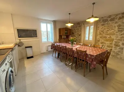 a dining room with a long table with chairs at Gîte de 12 personnes au cœur d'un domaine viticole in Gruissan