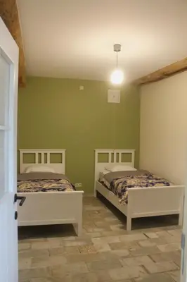 two beds in a room with green walls at Gîte - La Couderquié in Lautrec