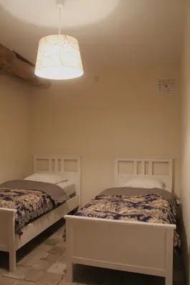 a bedroom with two beds and a light fixture at Gîte - La Couderquié in Lautrec