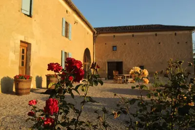 a courtyard of a building with flowers in the foreground at Gîte - La Couderquié in Lautrec