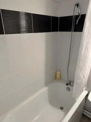 a white bath tub with a black and white tile wall at Studio COSY à deux pas de la PLAGE ! in Gruissan