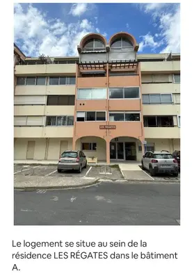 a building with two cars parked in a parking lot at Studio COSY à deux pas de la PLAGE ! in Gruissan