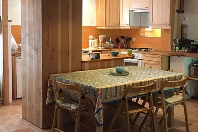 a kitchen with a table with chairs and a table cloth at Charme Zen Ecrin de verdure Fraîcheur Spa in Pezens