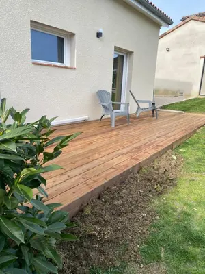 a wooden deck in front of a house with a chair on it at Tiny-house chez l'habitant in Lautrec
