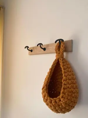 a brown crocheted bag hanging on a wall at Tiny-house chez l'habitant in Lautrec