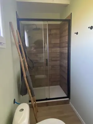 a bathroom with a shower and a toilet in a room at Tiny-house chez l'habitant in Lautrec