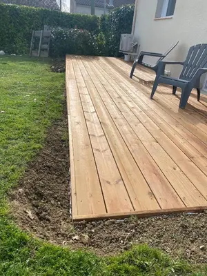 a wooden deck with a bench on a yard at Tiny-house chez l'habitant in Lautrec