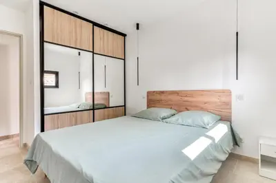 a bedroom with a large bed with a wooden headboard at L'appenti in Luc-sur-Orbieu
