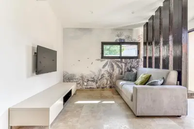 a living room with a couch and a tv at L'appenti in Luc-sur-Orbieu