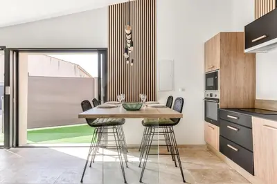 a kitchen with a wooden table and stools at L'appenti in Luc-sur-Orbieu