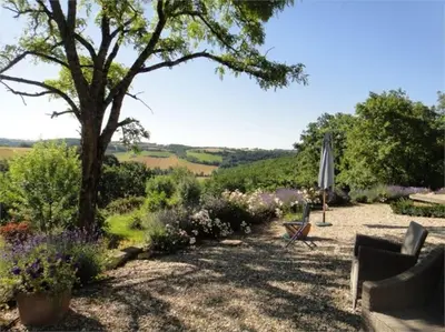 a garden with a tree and an umbrella and flowers at Villa - Mas de campagne prestigieux- Authentic french countryhouse in dream countryside in Algans