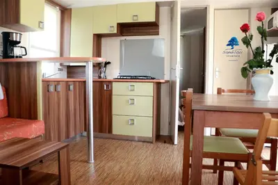 a small kitchen and dining room with a table at Mobilhome «Aux Portes du Soleil» in Sigean