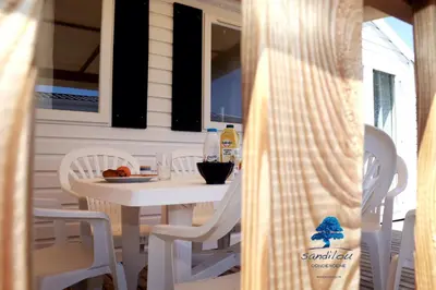 a white table and chairs on a porch at Mobilhome «Aux Portes du Soleil» in Sigean
