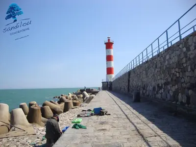 a lighthouse on the beach with a man standing in front at Mobilhome «Aux Portes du Soleil» in Sigean
