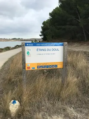 a sign in the grass next to a road at Mobilhome «Aux Portes du Soleil» in Sigean