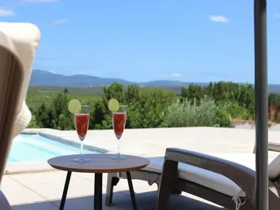 two wine glasses on a table next to a pool at Panorama in Rieux-Minervois