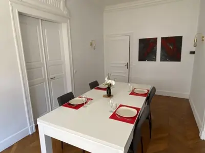 a white table with red napkins and plates on it at Appartement - 2 chambres - Parking voiture in Mazamet
