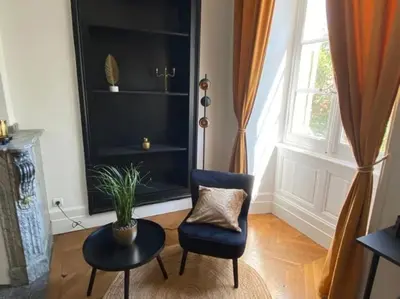 a living room with a chair and a table and a window at Appartement - 2 chambres - Parking voiture in Mazamet