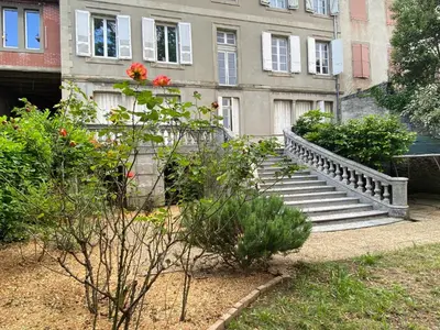 a staircase in front of a building with flowers at Appartement - 2 chambres - Parking voiture in Mazamet