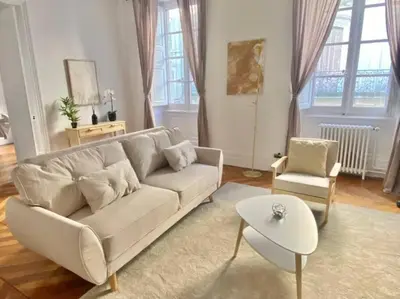 a living room with a white couch and a chair at Appartement - 2 chambres - Parking voiture in Mazamet