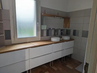 a bathroom with two sinks and a window at La Fontaine in Montgaillard-Lauragais