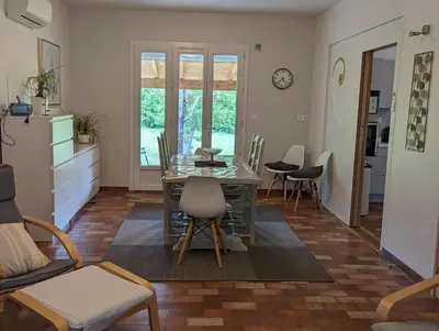a kitchen and living room with a table and chairs at La Fontaine in Montgaillard-Lauragais