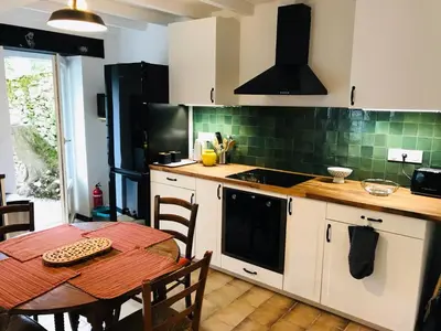 a kitchen with a table and a stove top oven at Gîte des Canelles in Villespy