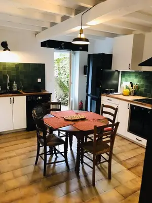 a kitchen with a table and chairs in a kitchen at Gîte des Canelles in Villespy