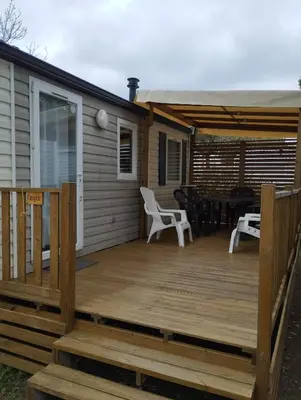 a wooden deck with a table and chairs on it at Mobil home in Port-la-Nouvelle