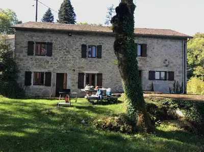 a group of people sitting in front of a stone house at Maison en pierre dans le Sidobre in Le Bez