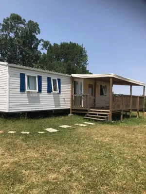 a mobile home with a porch and a deck at Mobil home 3 CH in Damiatte
